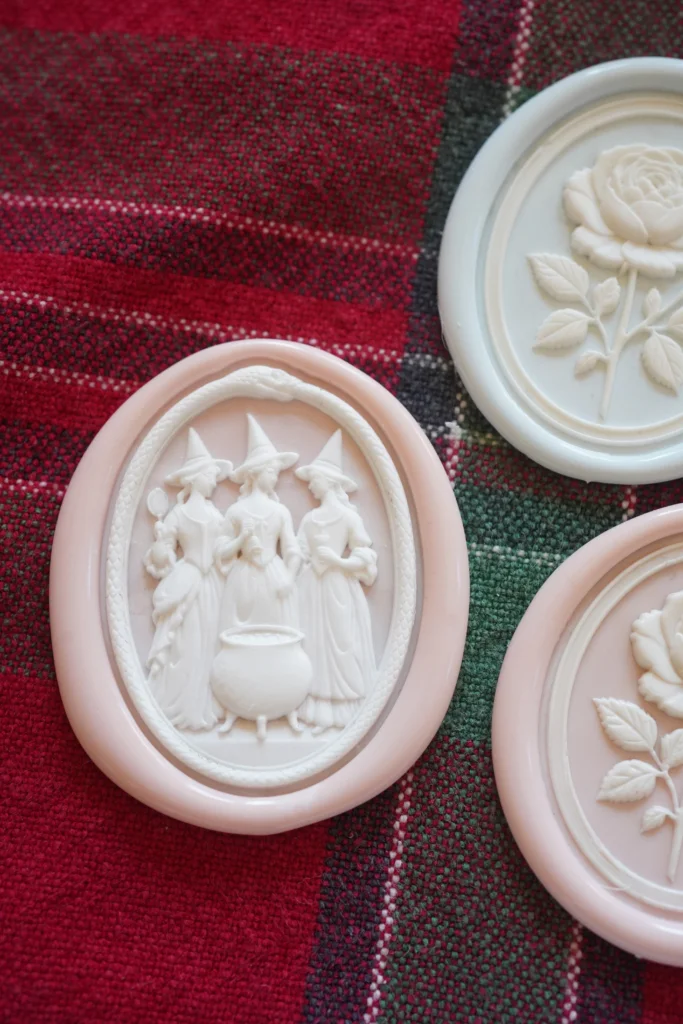 Intricate witch-themed wax seal design on dark background