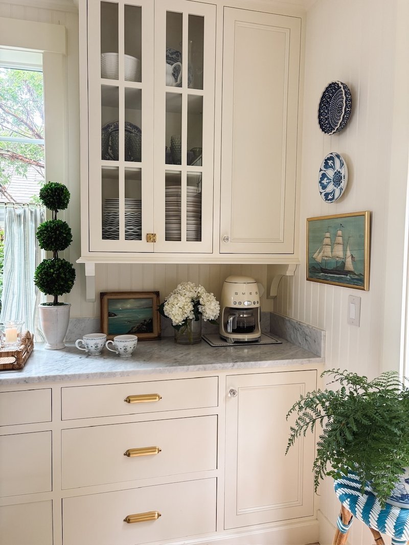 Cozy kitchen nook with flowers and cream cabinets