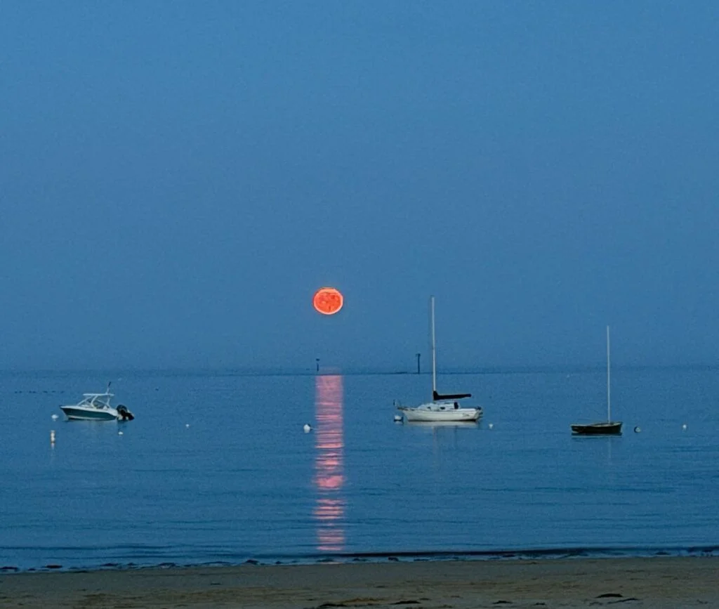 Golden moon reflection stretching across ocean water