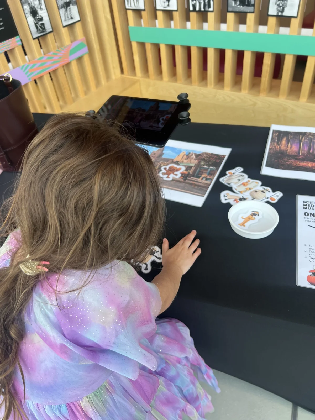 Child using a tablet at an interactive museum exhibit table
