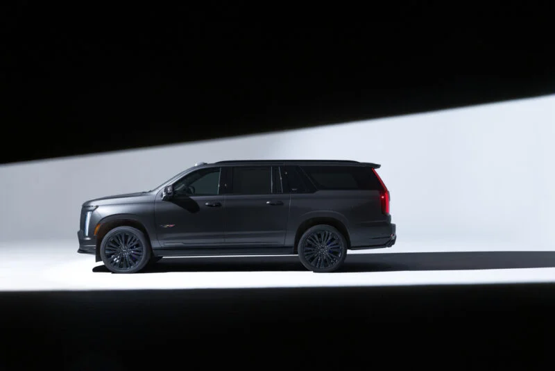 Dark gray Escalade-V side profile in dramatic studio lighting