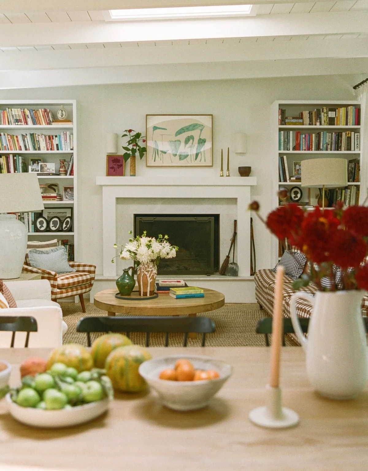 Cozy living room with fireplace, bookshelves, and a harvest table spread