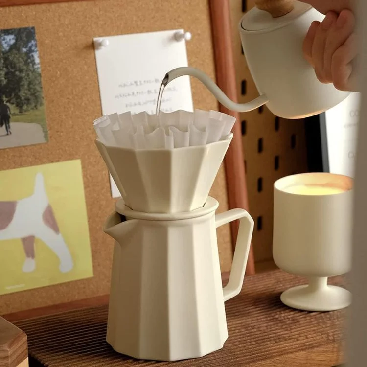 Pour-over coffee being brewed from a white kettle